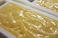 Picture of our goat milk soap after just being poured in the mold. Soap is a light tan color and looks wet and creamy.