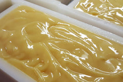 Picture of our goat milk soap after just being poured in the mold. Soap is a light tan color and looks wet and creamy.