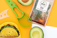 Taco coin purse, avocado, Fiesta dip packet with colorful spices inn green and red, avocado pitter tool and avocado on yellow background. 