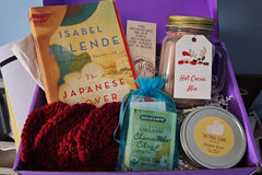 A sampling of what a box may look like - book, bookmark, handknit coasters, teabag, candle, and hot cocoa!!