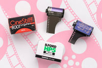 Example film bundle.  Four films shown on pink patterned background. Brands shown: CineStill, Ilford, Atlanta Film Co.