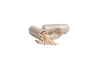 two clear-coated pills which have been opened. A little powder is falling from the inside of the capsules. 
