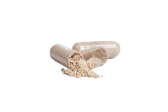 two clear-coated pills which have been opened. A little powder is falling from the inside of the capsules. 