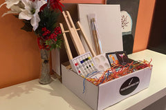 Enjoy a Paint and Sip Box or give as a gift. Each box contains an easel, a canvas, paint, a tray, and brushes. 
