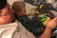 Father and son reading together, enjoying a moment of learning with the Little Dreamers Club Crafts Subscription Box