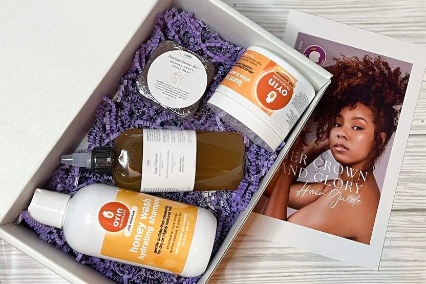 Hair care products in Her Crown and Glory Subscription Box sitting on side of Her Crown and Glory’s Hair Guide