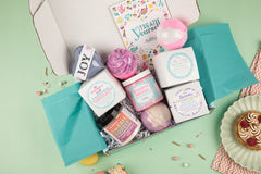 Treat Yourself Bath Bevy Subscription box with bath bombs, whipped soap scrub, bubble rubble against a light green background
