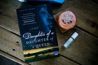 A red mug filled with three packets of Moonstruck milk chocolate, featured in the Peace & Pages monthly subscription box