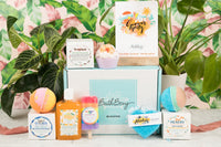 Bath Bevy Subscription box with bath bombs, soothing mango aloe gel, rainbow popsicle soap on a tropical background
