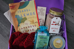 A sampling of what a box may look like - book, bookmark, handknit coasters, teabag, candle, and hot cocoa!!