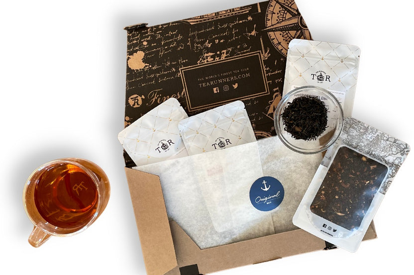 Teas Runners Subscription open box - featuring 4 loose leaf tea pouches and a cup of steeped tea.