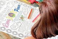 Young lady coloring an 18"x24" coloring page with Love, Joy, Peace, Patience, Kindness, Faithfulness printed on it. Pink, Yellow, and Blue.