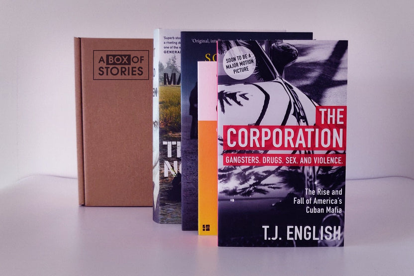 Brown subscription box filled with four light reading books, featuring charming stories and uplifting themes for easygoing book lovers.