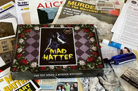 A Murder Mystery in a Box subscription box surrounded by newspapers, clues and other things to solve a Mad Hatter mystery.