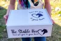 Image showing girl holding The Stable Box Subscription wearing one of the graphic tees included in the monthly box.