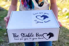 Image showing girl holding The Stable Box Subscription wearing one of the graphic tees included in the monthly box.