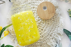 mason jar glass can snow globe cup. Inside are lemon sprinkles with yellow glitter. Bamboo lid and straw.