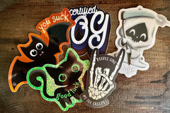 Example stickers including glitter good luck cat, glow in the dark people give me the creeps and holographic you suck bat stickers.