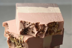 Pink, white and purple layered bars of soap stacked on top of each other. This is the Oatmilk soap. 