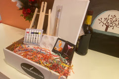 Enjoy a Paint and Sip Box or give as a gift. Each box contains an easel, a canvas, paint, a tray, and brushes. 