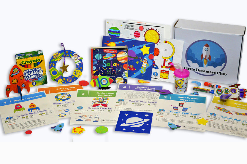 "Little Dreamers Club box with solar system themed crafts, book, art supplies, a DIY project, a sticker scene, and coloring pages."