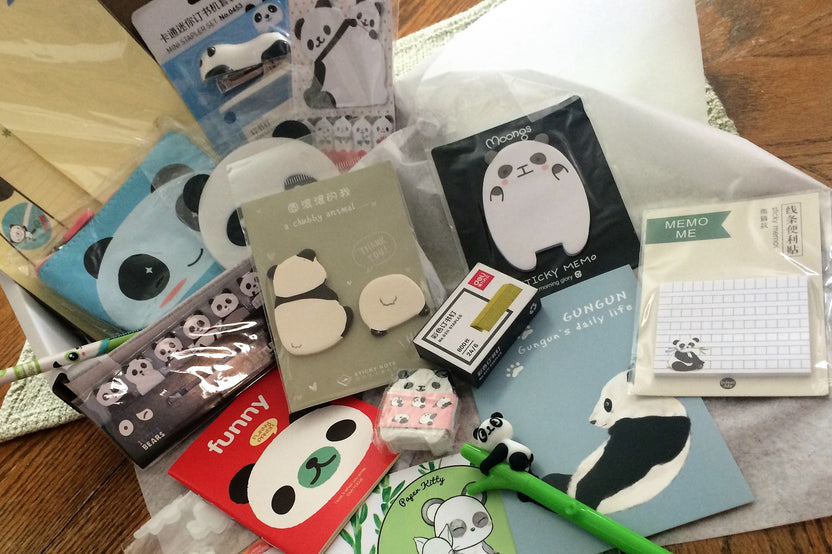 Assorted panda-themed stationery items from the Paper Overhaul subscription box, featuring notepads, stickers, and pens