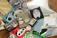 Assorted panda-themed stationery items from the Paper Overhaul subscription box, featuring notepads, stickers, and pens
