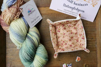 Beautiful Hand Dyed Yarn twisted into a Skein along with lovely extra items that are consistent with the colorway 's theme