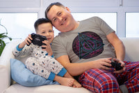 A man and young boy playing video games. The man is wearing a Deathly Hallows Tshirt with a Triangle design.