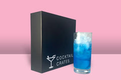 A Cocktail subscription box displaying a negroni cocktail in front of a gift box from Cocktail Crates