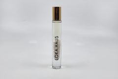 Tall bottle with gold cap: LOKA.HAUS's 'Intensity Parfum Roller'. Luxurious scent, crystal clarity. Elegance rolls on.